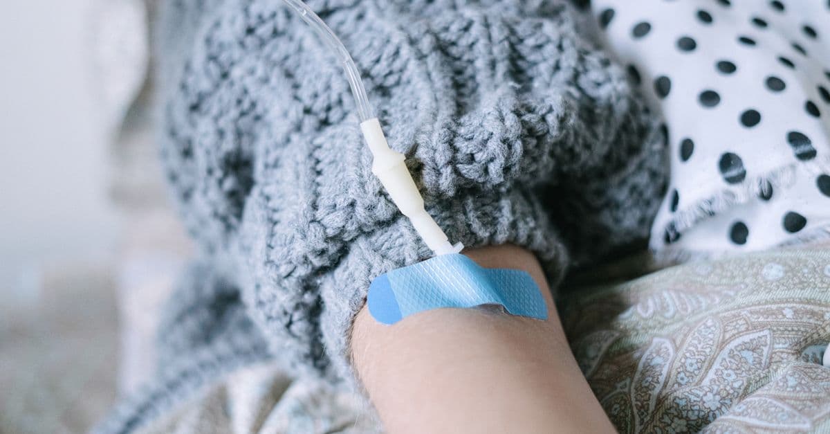 Close-up of a patient receiving intravenous therapy during cancer treatment.